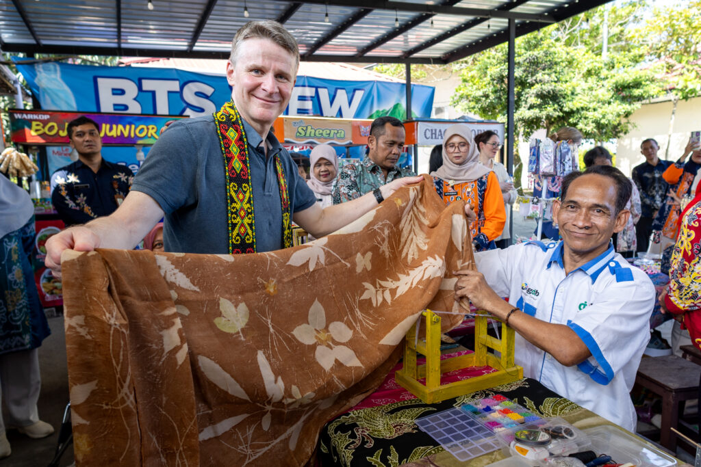 Australian Ambassador Rod Brazier showcases ecoprint fabric created by people with disability in Kalimantan.